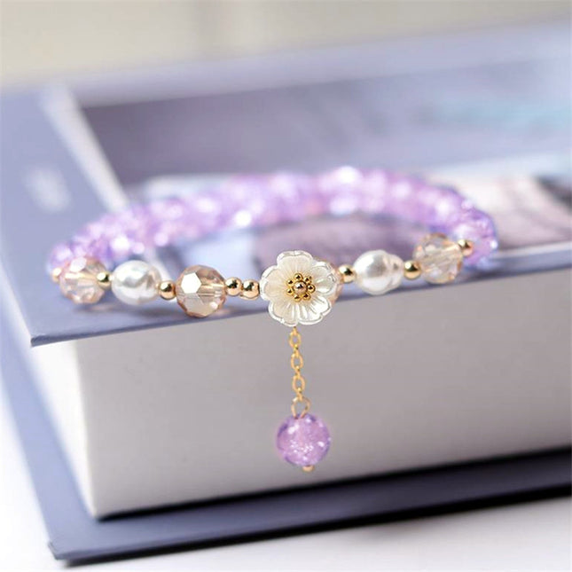Elegante pulsera de flores blancas con cuentas moradas