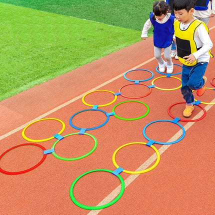 Juego de saltos con aro de rayuela para niños al aire libre