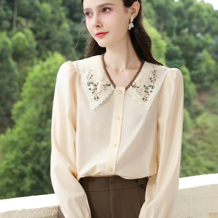 Elegante blusa de otoño con solapa bordada y mangas abullonadas